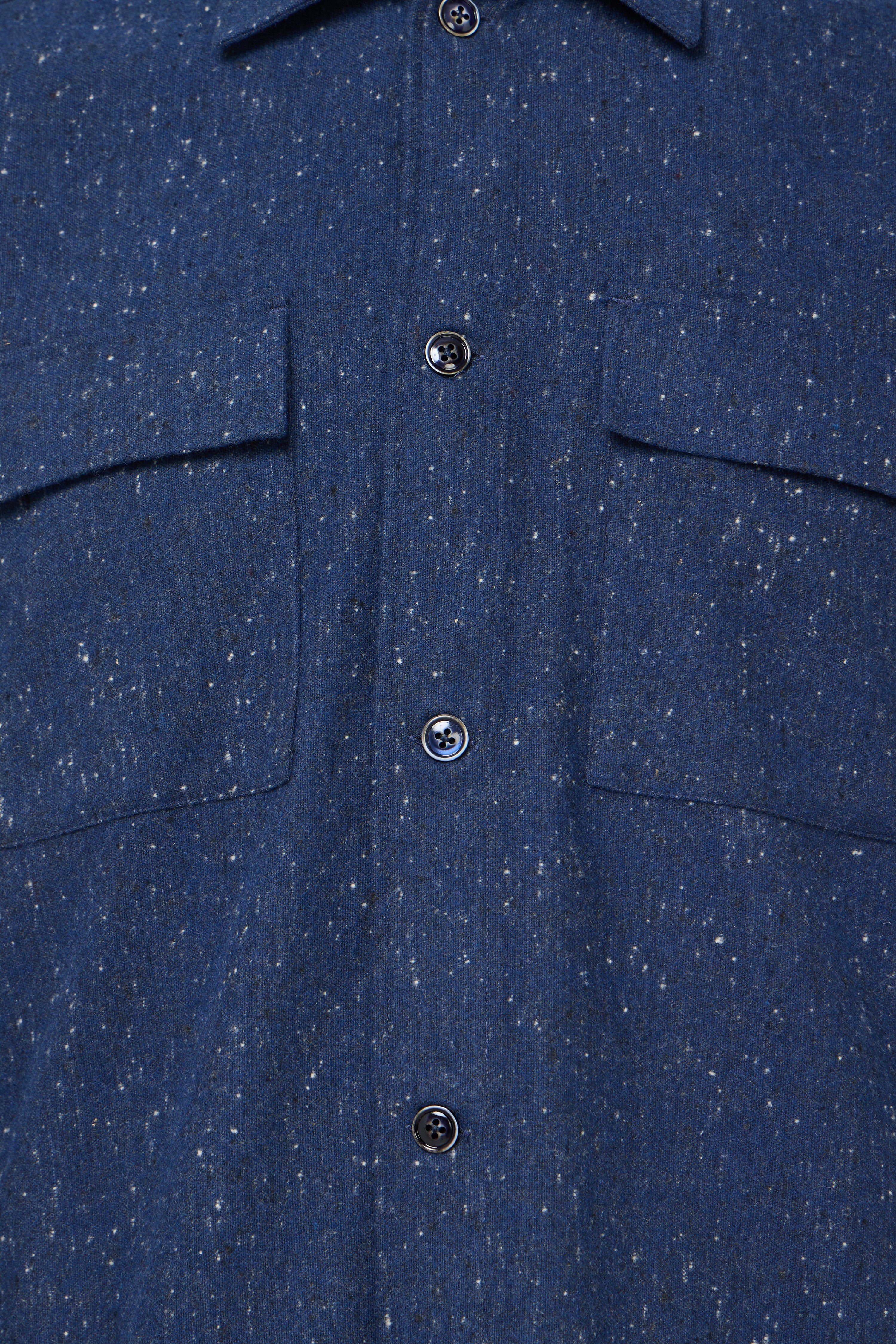 Close-up of a blue textured shirt with buttons
