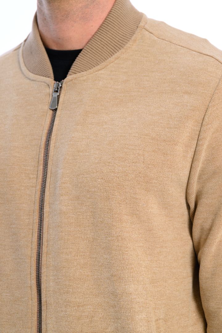 Close-up of a beige bomber jacket with a zipper on a white background