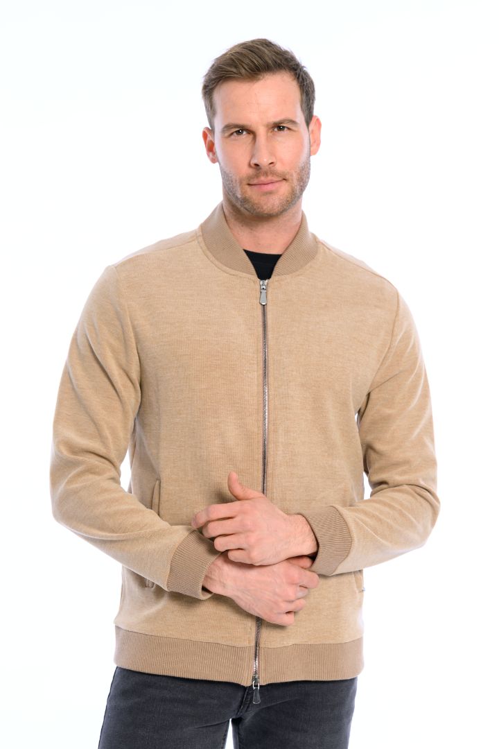 Man wearing a beige zip-up sweater on a white background