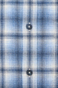 Load image into Gallery viewer, Close-up of a blue and white plaid shirt fabric with buttons.
