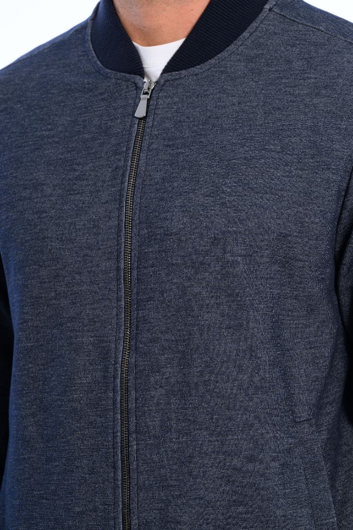 Close-up of a dark gray zip-up jacket with a white shirt underneath.