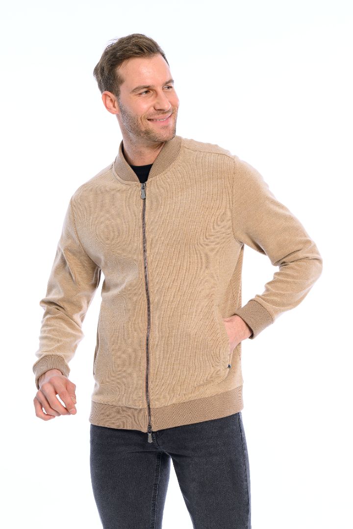 Man wearing a beige zip-up sweater on a white background